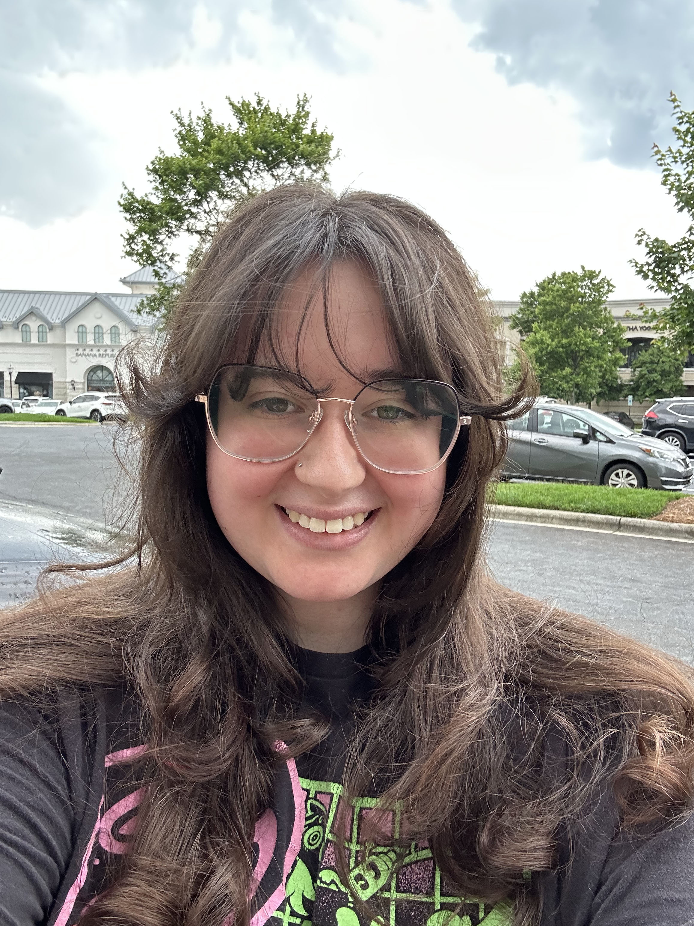 Cassidy, a young woman with brown hair and wearing glasses, smiles at the camera.