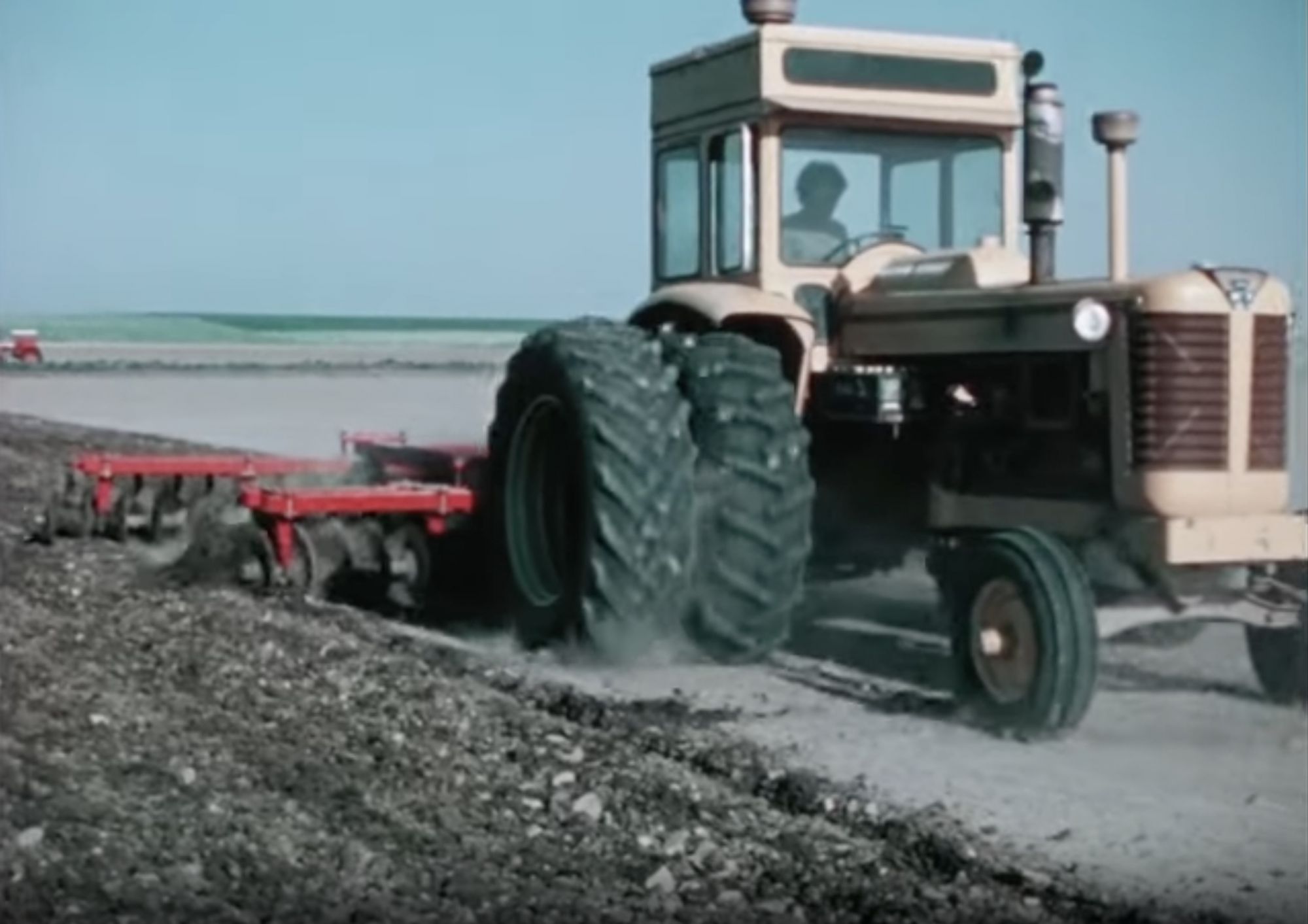Photo of a tractor, plowing a field.