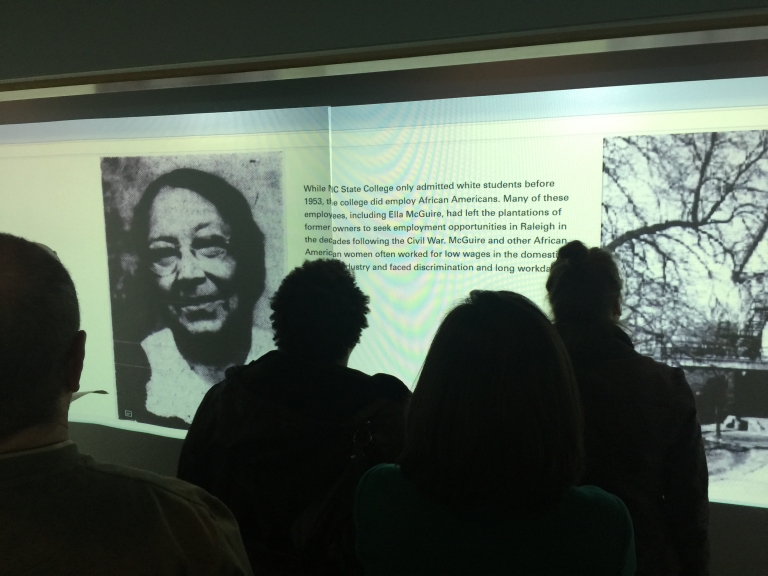History 596 presenting the Soldiering On virtual exhibit in the DH Hill Library's Visualization Studio on 11 December 2017.  The section depicted here shows Ella McGuire, an African American who nursed NC State students during the pandemic.