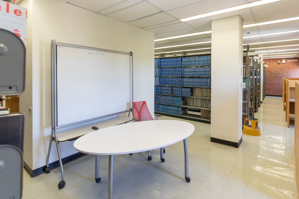 Large table with moveable whiteboard and task chair.